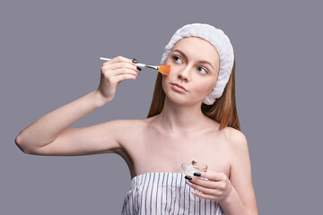 Facial peeling. Pretty girl with cosmetology brush. Anti acne mask. Home skin care routine....