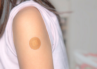 A little girl with a vaccine bandage after being vaccinated.