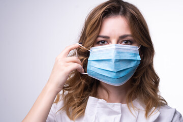 Protection against contagious disease, coronavirus. Female  wearing hygienic face surgical medical mask. Banner panorama medical staff preventive gear. Studio Photo, White edit space