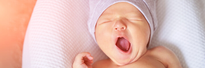 Tiny newborn in first hat. Pretty little people. Healthcare concept. Modern parenthood. Comfort and safety sleep on bed. Human insurance. Family miracle. Closed eyes and yawn. Banner. Copyspace