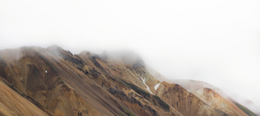 Panoramic view of surreal rhyolite mountains covered in clouds along the laugavegur trail in the highlands of Iceland