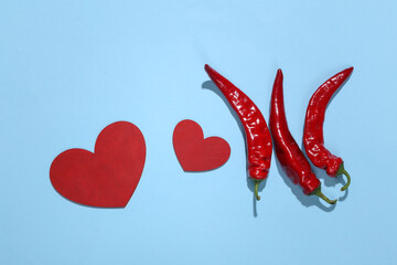Chilli pepper and heart on blue background. Love concept. Top view
