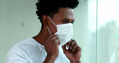 African american man putting covid mask, black person puts on virus prevention mask