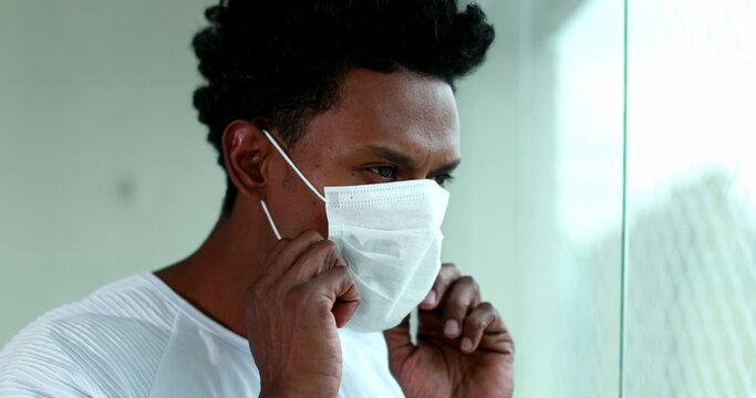 African american man putting covid mask, black person puts on virus prevention mask