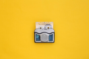 Mini audio player with audio cassette on yellow background. Top view