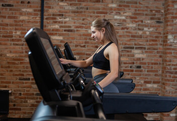 Obraz na płótnie Canvas Slim beautiful Woman doing cardio training on treadmill, working out in gym