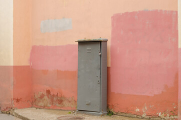 An old transformer booth against a pink wall