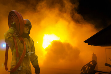 Firefighters Fight the raging fire with large flames burning gas leaking.