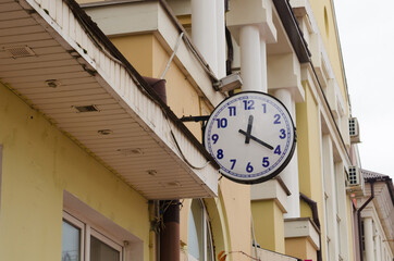 Street clock on the facade of the house