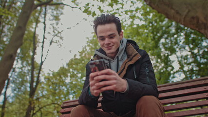 Handsome Man Teenager Talking on the Phone 4K slow motion positive park green trees nature youth happy nice white teeth tooth galsses cool lifestyle stylish conversation student using smart phone