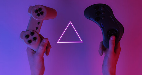 Gamer concept. Hands holding gamepads. Creative pop art pink blue neon color. Trendy gradient illumination. Night light © splitov27