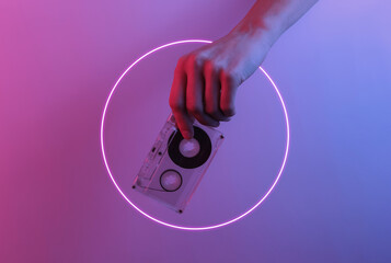 Retro wave 80s. Hand holding audio cassette. Creative pop art pink blue neon color. Trendy gradient...
