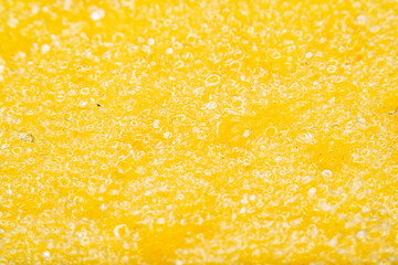Yellow background with close-up of kitchen sponge