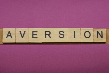 word aversion made from wooden letters lies on a lilac table