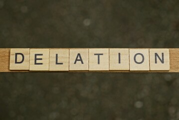 gray word delation from small wooden letters on a black table