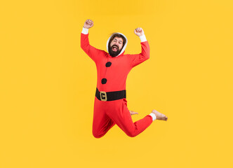 Fototapeta na wymiar Full length body size photo of man jumping with happiness dressed in santa claus costume on yellow background, new year happiness
