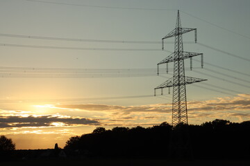 silhouette of a power mast in the evening