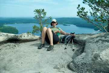 Smiling woman sitting on the top of rock