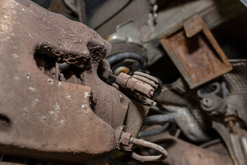 Old brake hose system, mounted to the car, close-up on the handbrake tensioning spring.