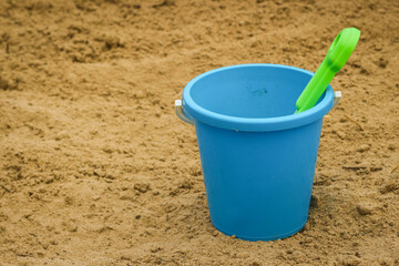 Fototapeta na wymiar Children's beach sand toys. Kids concept. Plastic children's toys. Blue bucket, colorful molds.