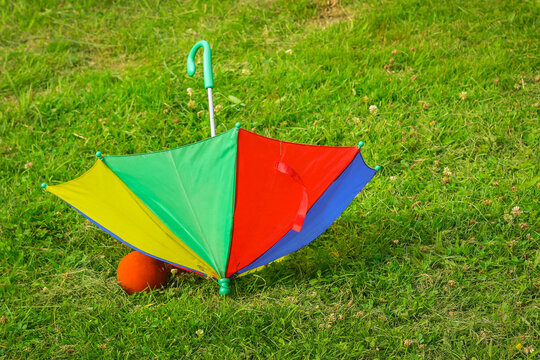 A colorful children's Umbrella on the green Lawn. The concept of a happy childhood.