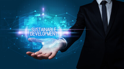 Man hand holding SUSTAINABLE DEVELOPMENT inscription, technology concept