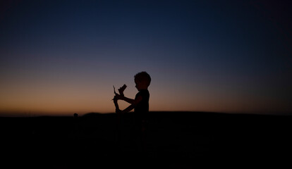 Fototapeta na wymiar The silhouette of a young boy in the desert sunset