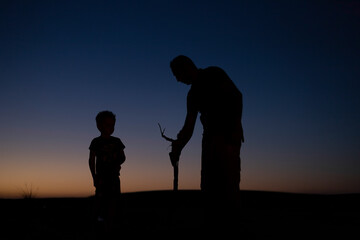 The silhouette of a young boy in the desert sunset