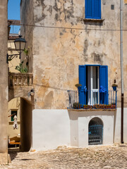 Fototapeta na wymiar Small square and house with blue shutters in Otranto (Puglia, Italy) downtown.