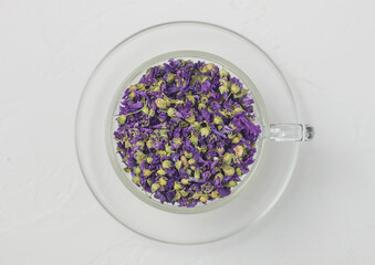 Blue mallow flowers tea in clear glass cup on white background.
