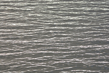 Silbern glänzendes Wasser mit leichten Windwellen