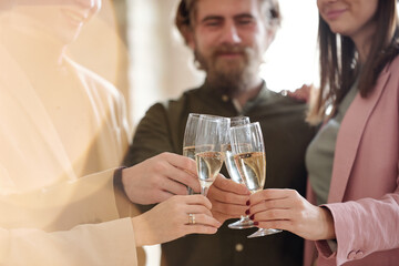Hands of young colleagues in smart casualwear toasting for business partnership
