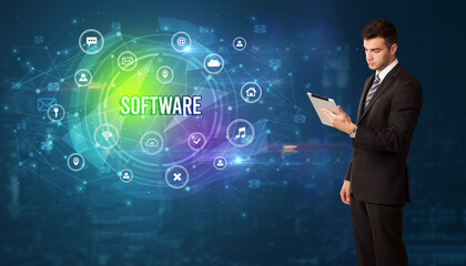 Businessman thinking in front of technology related icons and SOFTWARE inscription, modern technology concept