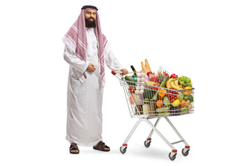 Arab man standing with a shopping cart full of food products