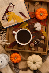 cozy autumn evening. a cup of coffee, books, plaid, pumpkin, cinnamon sticks, leaves