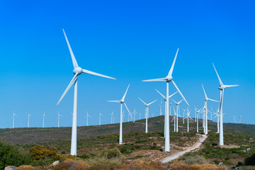 Aerial view large group of eco system wind turbines power generation station on green field in rural landscape in countryside