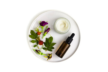 Cream and oil rose hip and female hands on white background. Composition on plate, skin care, flat lay