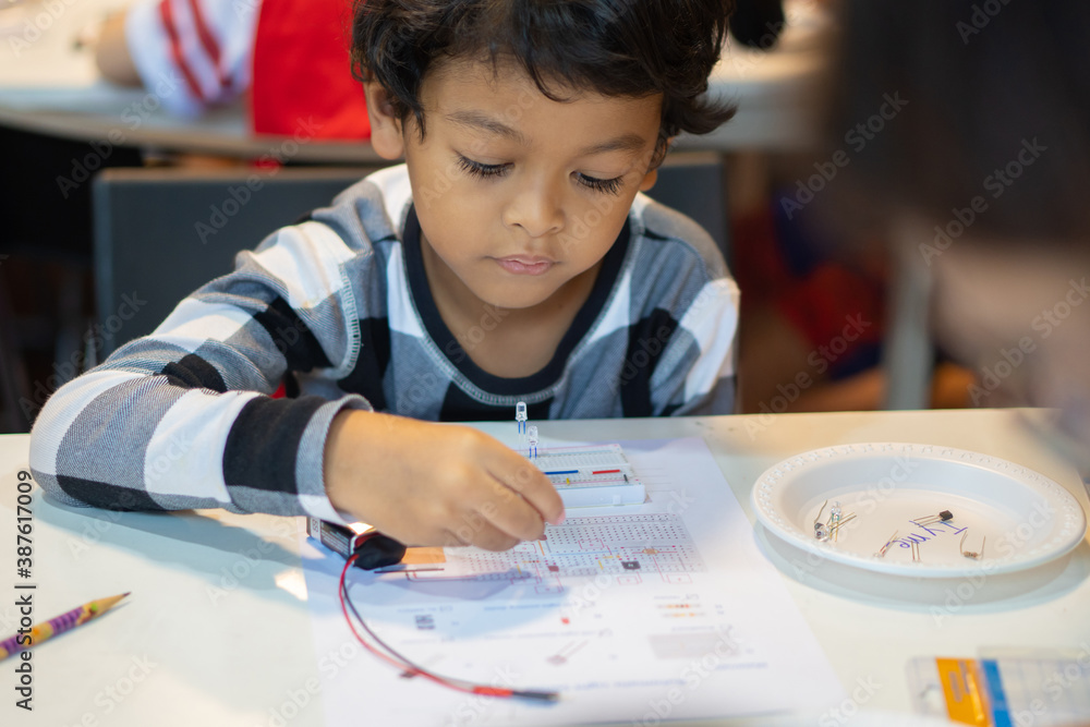 Aufkleber kid learn to connect electric circuits in the classroom.