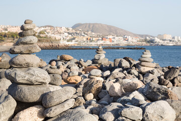Fototapeta na wymiar Piles of stones balanced on a beach in Costa Adeje, Tenerife