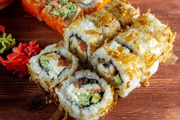 sushi rolls with salmon and smoked eel on a wooden table