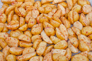 Raw chopped potatoes on a baking sheet.