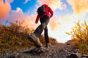 View of Woman Hiking Rocky Trail from Below during Fall in Canadian Nature. Sunset Sky Artistic...