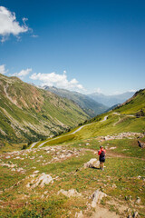 Fototapeta na wymiar un randonneur marchant dans les Alpes. Un randonneur dans les montagnes en été.