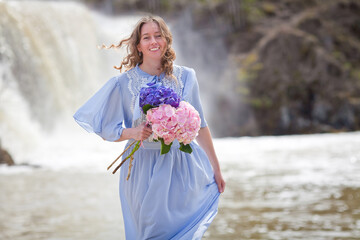 girl with a bouquet of hydrangeas walks on the shore, spring photo session