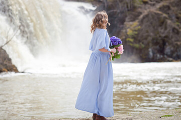 girl with a bouquet of hydrangeas walks on the shore, spring photo session
