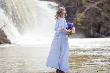 girl with a bouquet of hydrangeas walks on the shore, spring photo session