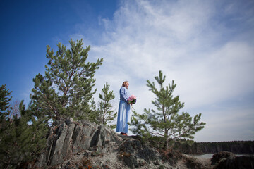 girl with a bouquet of hydrangeas walks on the shore, spring photo session