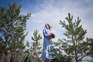 girl with a bouquet of hydrangeas walks on the shore, spring photo session