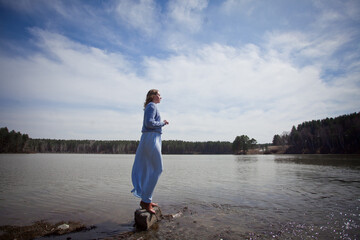 girl with a bouquet of hydrangeas walks on the shore, spring photo session