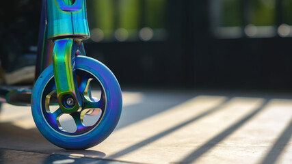 Wheel of rainbow colored stunt scooter.